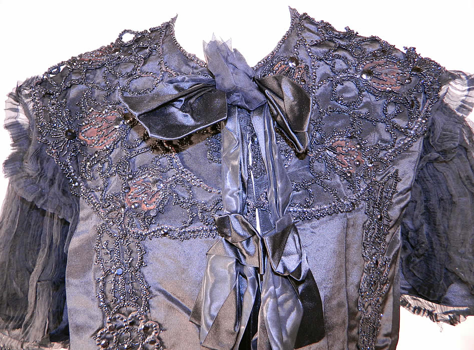 Victorian Black Silk Jet Beaded Mourning Mantle Dolman Cloak Cape Capelet
This stunning short cropped cloak cape capelet dolman mantle has black silk ribbon bow trim down the front with hook closures and is fully lined with a white silk fabric weighted along the bottom inside. 