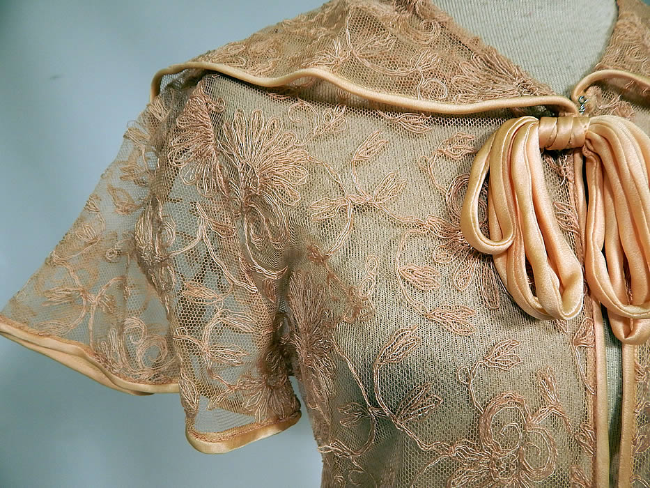 Vintage I. Magnin & Co Pink Tambour Embroidery Net Lace Peignoir Robe Dressing Gown
This lovely lingerie peignoir robe boudoir dressing gown is a long floor length, with a form fitting style, short flared sleeves, a shawl collar, bow tie neck, silk covered buttons for closure down on front and is sheer, unlined. 