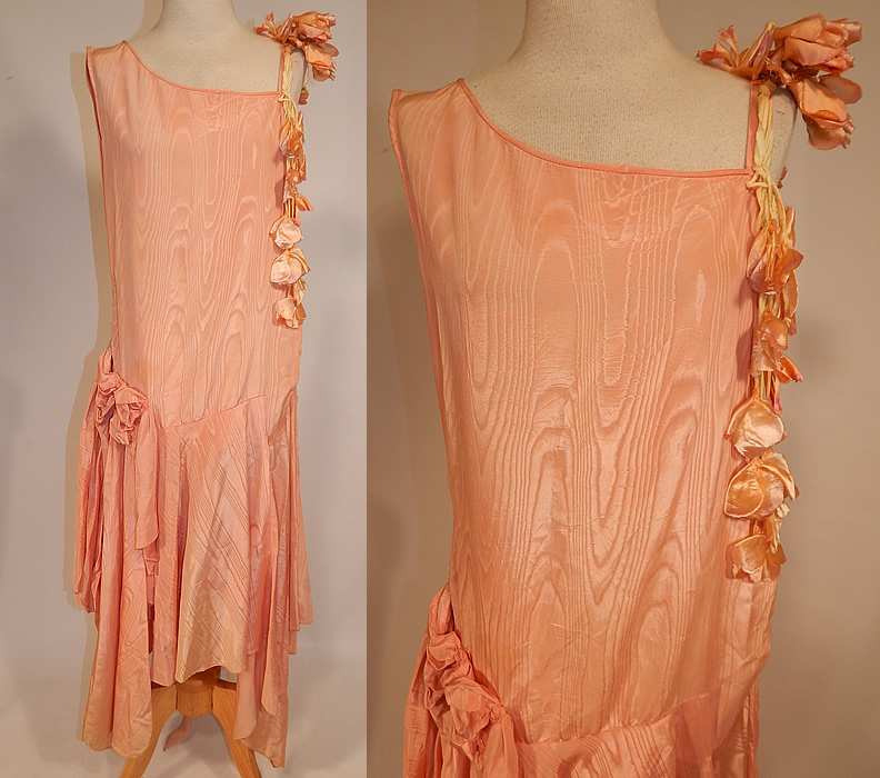 Vintage Peach Silk Moire Sweet Pea Flower Handkerchief Skirt Drop Waist Dress
This vintage peach silk moire sweet pea flower handkerchief skirt drop waist dress dates from the 1920s. It is made of a peachy pink pastel color silk taffeta moire wavy watered appearance fabric, with peach silk sweet pea flowers cascading down one shoulder.