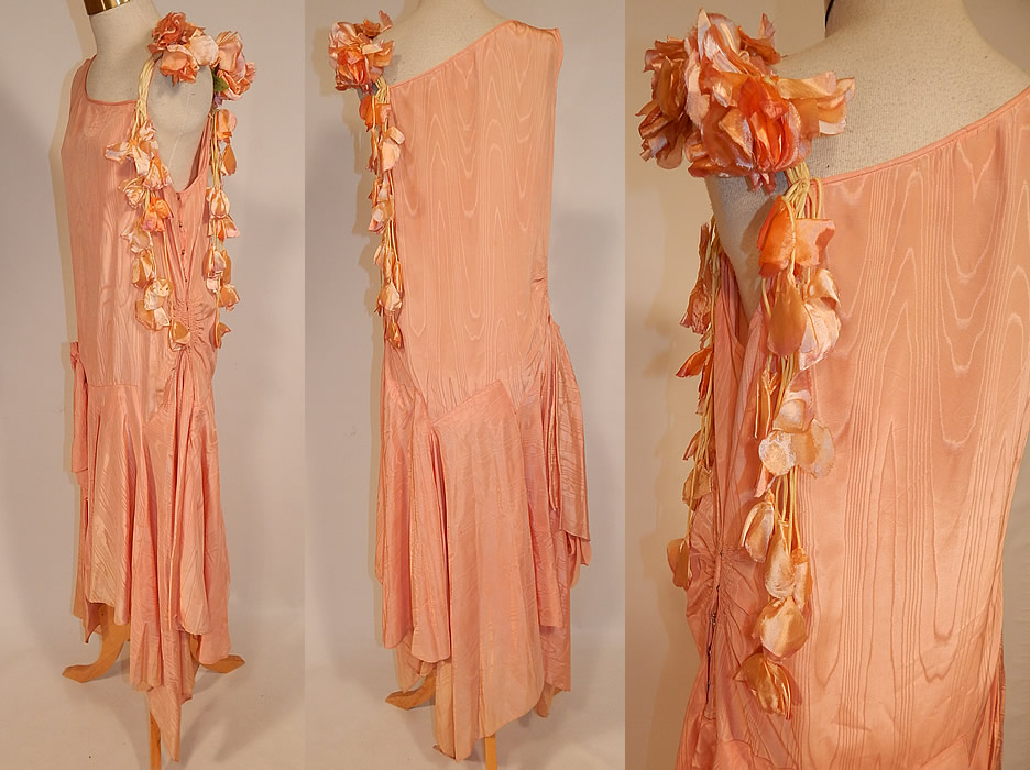 Vintage Peach Silk Moire Sweet Pea Flower Handkerchief Skirt Drop Waist Dress
This fabulous flapper drop waist dress is sleeveless, with a one shoulder style, flowers trimming the spaghetti strap along the other shoulder, an uneven asymmetrical handkerchief hemline full wrap split skirt, longer along the sides, with side gathering, side snap closures and is unlined. The dress measures 42 to 48 inches long with varying lengths, a 34 inch waist and 38 inch bust. It is in good condition, with only some slight fade discoloration along the bottom skirt creating a ombre effect. This is truly a wonderful piece of Art Deco wearable textile art!
