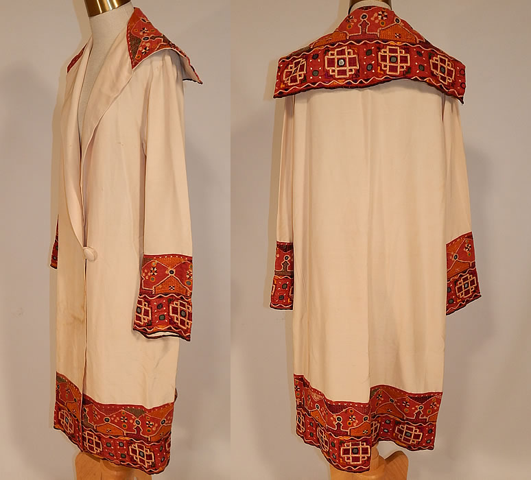 Vintage Indian Gujarati Kutch Work Embroidery Mirrored Art Deco Cocoon Coat
There are small mirrors embroidered into the decorative designs. This amazing Art Deco cocoon wrap coat is loose fitting, has a long mid length style, with a embroidered large fold over shawl sailor collar, long full sleeves with embroidered wide cuffs, an embroidered trim hem skirt, single button closure on the drop waist and is unlined.