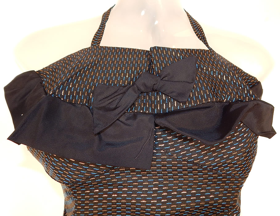 Unworn Vintage Tern Floating Sportswear Gold Lam&eacute; Lame Halter Pinup Swimsuit
It is made of a black, blue and gold lam&eacute; dashes design pattern fabric. This retro pinup style womens one piece bathing has a halter top adjustable necktie strap, black bow tie, ruffle trim front top, gathering along the sides, elastic ruche gathered smocking on the back and a skirt skort panty bottom. 