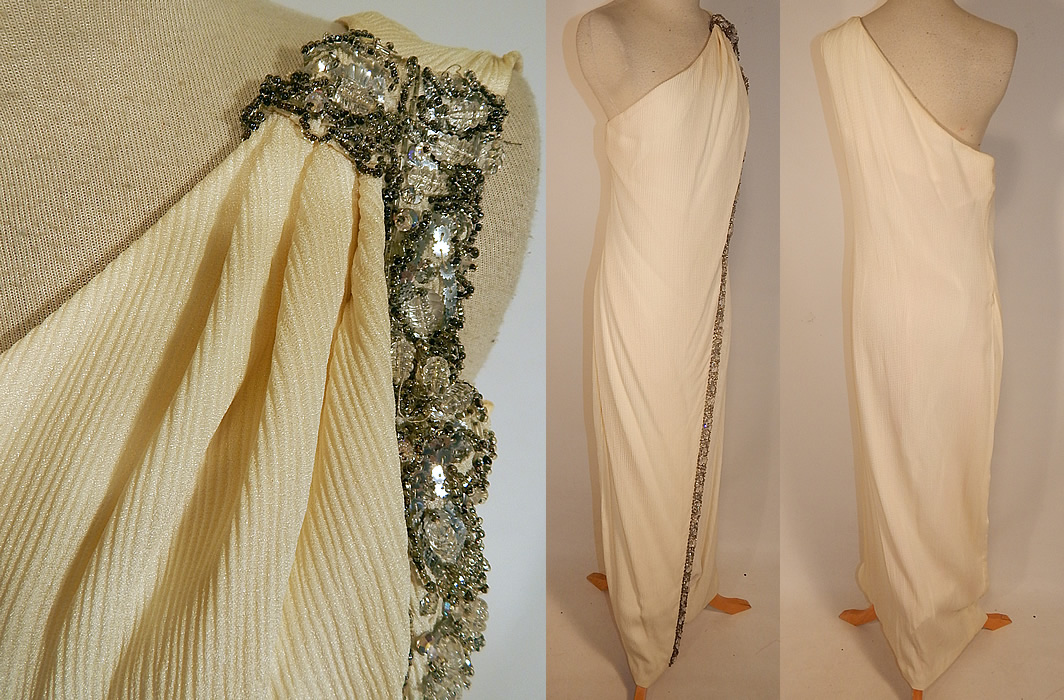 Vintage White Silk de Chine Silver Beaded One Shoulder Grecian Goddess Gown
This gorgeous Grecian goddess gown is a long floor length, with a wrap front slit skirt, one shoulder sleeveless style neckline, a side zipper closure, hooks on the shoulder and is fully lined. The dress measures 53 inches long, with 36 inch hips, a 30 inch waist and 34 inch bust.