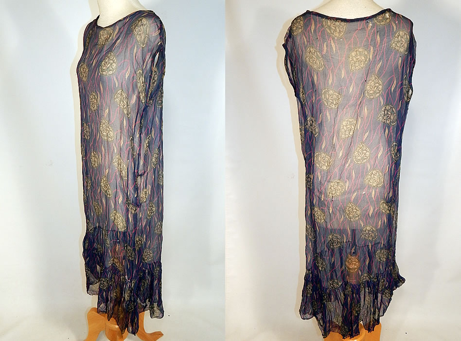 Vintage Art Deco Navy Blue Green Leaf Abstract Print Silk Chiffon Drop Waist Dress
This delightful day dress has a loose fitting straight shift, drop waist style, a sleeveless top, ruffle bottom skirt and is sheer, unlined.