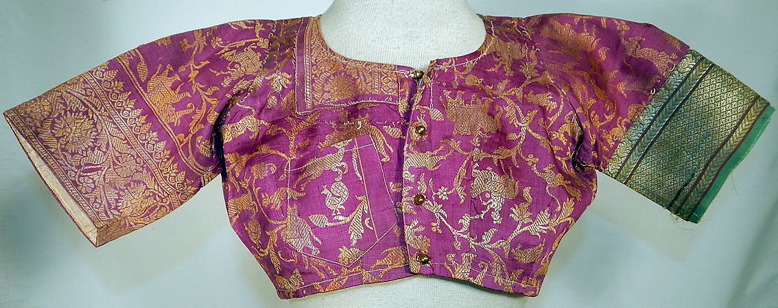 Vintage 19th Century Indian Purple Silk Sari Gold Lamé Lame Choli Crop Top Blouse
It is made a purple and gold lamé silk sari fabric with a woven floral fauna design of animals, tigers, deer, peacocks and hunters riding horses and elephants. 