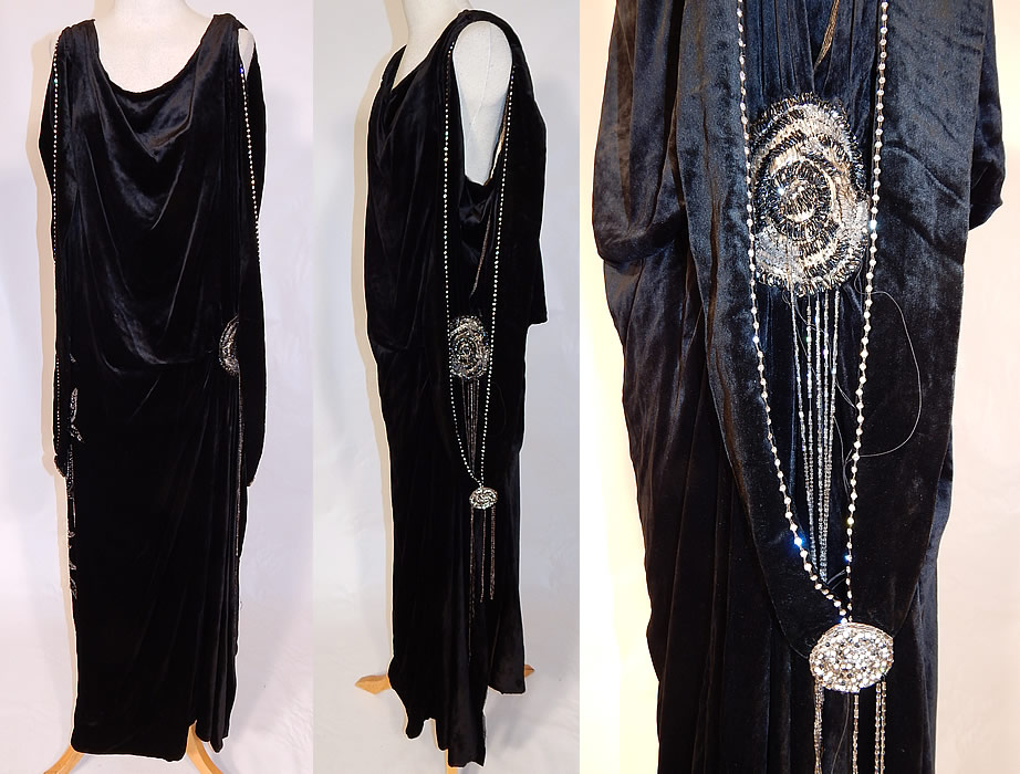 Vintage Art Deco Black Velvet Silver Rhinestone Beaded Flapper Dress Evening Gown
This vintage Art Deco black velvet silver rhinestone beaded flapper dress evening gown dates from the 1920s. It is made of a black silk velvet fabric, with silver crystal hand bead work and prong set rhinestone accents done in a floral motif design along the side. 