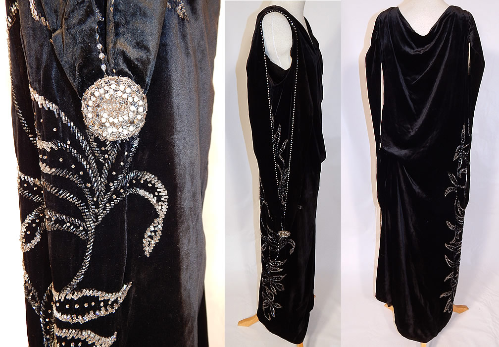 Vintage Art Deco Black Velvet Silver Rhinestone Beaded Flapper Dress Evening Gown
This fabulous flapper dress evening gown has a loose fitting drop waist style, with beaded rosette medallion fringed appliqu&eacute; trim on the sides, long dramatic draping armhole shoulder strap loops, is sleeveless, with a long floor length skirt, shoulder snap closures and is fully lined with a built in white silk camisole top lining inside.