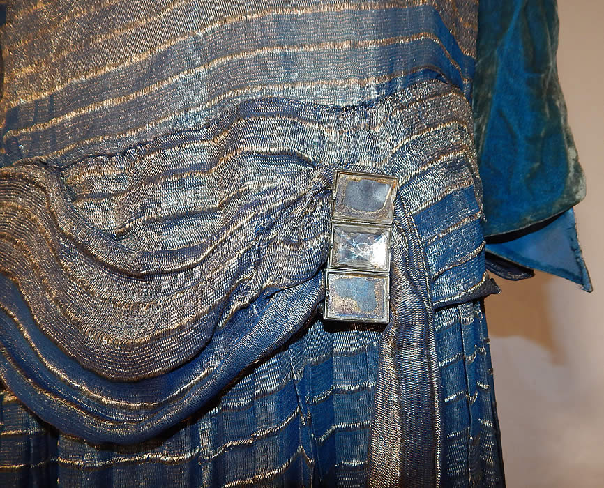 Vintage Art Deco Striped Blue & Gold Lamé Lame Velvet Drop Waist Flapper Dress
This vintage Art Deco striped blue and gold lamé velvet drop waist flapper dress dates from the 1920s. It is made of a blue and gold metallic silk lamé fabric, with a striped pattern design and blue silk velvet trim accents.