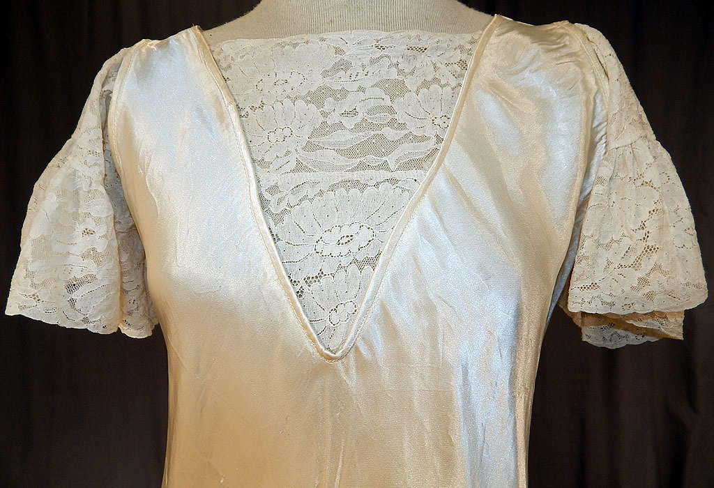 Vintage White Silk Satin & Lace Asymmetrical Bias Cut Wedding Gown Dress
This beautiful bridal bias cut long floor length wedding gown dress has an asymmetrical decorative stitched style skirt, with lace ruffle flared short sleeves, a modesty lace insert panel V front neckline, no closures and is unlined.