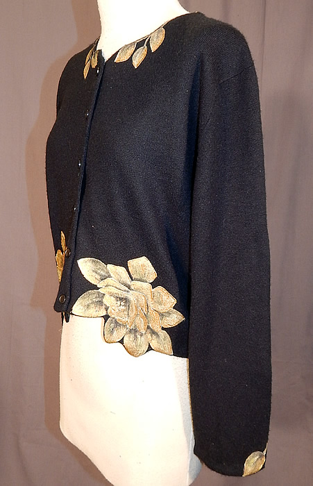 Vintage Marge Wing Black Cashmere Gold Hand Painted Magnolia Cardigan Sweater
It is made of a black soft cashmere wool fabric, with a hand painted gold magnolia flower design creating a scalloped petal design along the bottom hem and leaf accents painted on the collar and cuffs. 