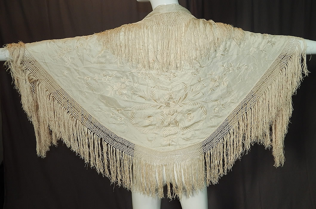 Antique Edwardian Cream Silk Embroidered Fringe Piano Shawl Wedding Cape
This antique Edwardian era cream silk embroidered fringe piano shawl wedding cape dates from 1910. It is made of an off white cream color silk fabric, with raised padded satin stitch hand embroidery work flowers. 