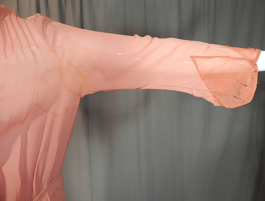 Vintage Art Deco Old Rose Pink Silk Crepe de Chine Appliqu&eacute;d Belted Bias Cut Dress
The dress measures 52 inches long, with 38 inch hips, a 32 inch waist, 38 inch bust and 20 inch long sleeves. It is in fair as-is condition, with several faint water spot stains, underarm stains, some frayed splits on the silk appliqu&eacute; sleeve cuff trim (see close-ups). This is truly a wonderful piece of Art Deco textile art which would be great for design and pattern!