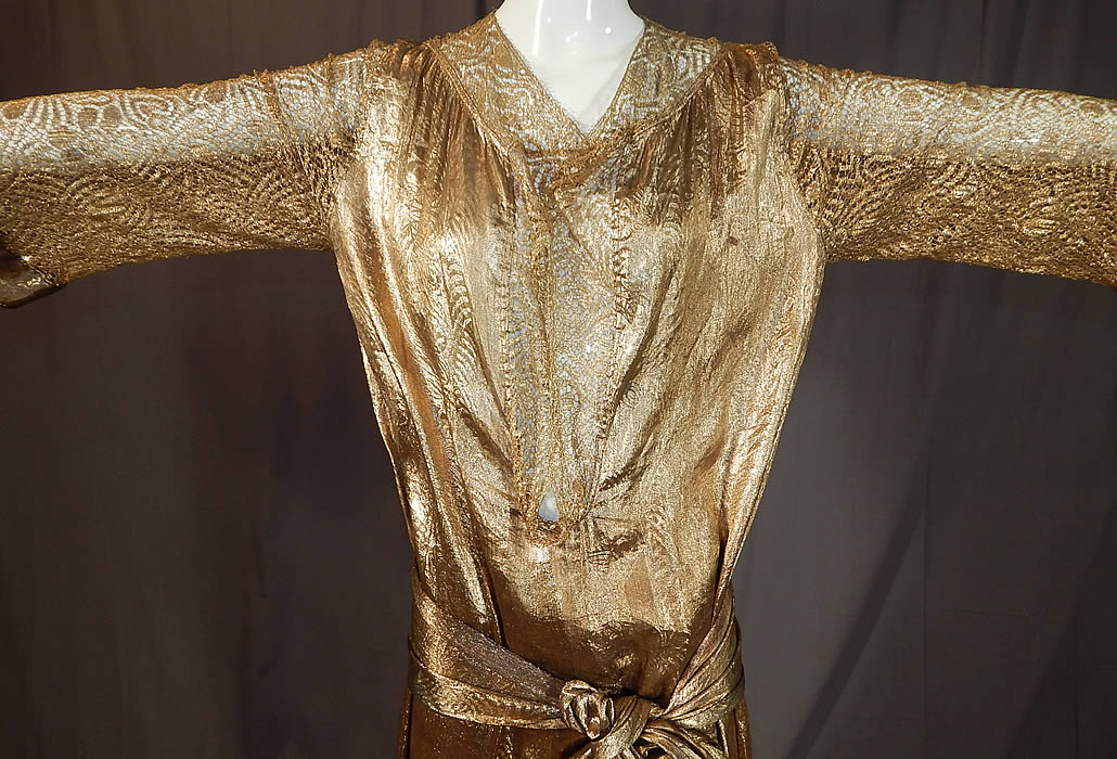 Vintage Art Deco Gold Lam&eacute; Lame Lace Belted Sash Scarf Shift Kaftan Flapper Dress
It is made of a gold metallic silk lam&eacute; damask weave brocade fabric with a woven abstract floral leaf design and sheer gold metallic lace flower pattern sleeves. 