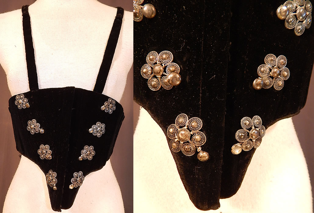 Victorian Black Velvet Silver Trim Swiss Waist Corselet Corset Vest Bodice
This antique Victorian Civil War era black velvet silver trim Swiss waist corselet corset vest bodice dates from the 1860s. It is made of a black velvet fabric, with silver metal raised filigree flower shaped button trim on the front.