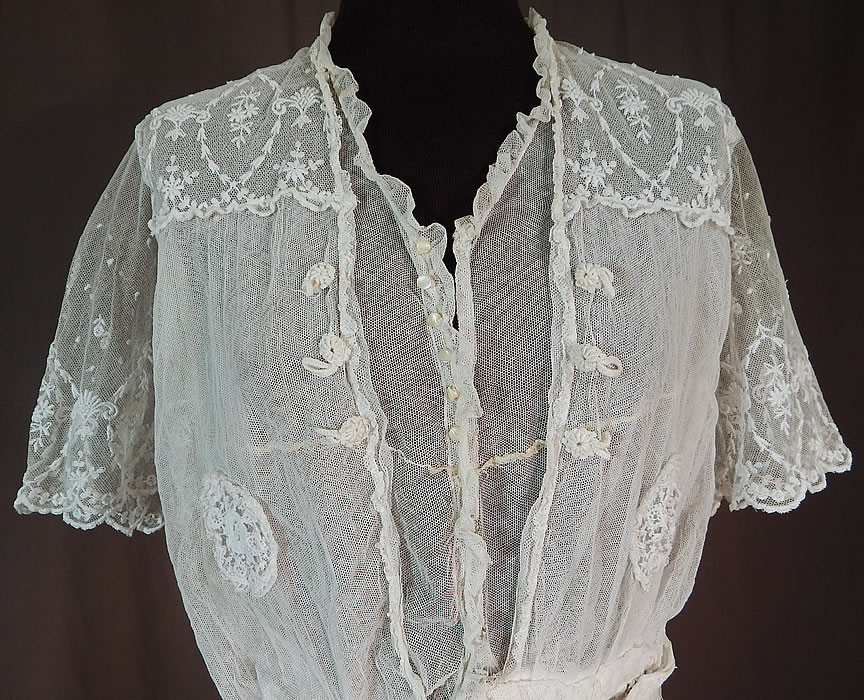 Titanic Edwardian Embroidered White Tulle Net Lace Applique Dress Tea Gown
This lovely lace dress is a tea gown length, with a layered tiered skirt, ruffle edge top with tiny mother of pearl button trim, snap closures down the front, a layered over blouse with short sleeves, fitted waistband and is sheer, unlined.