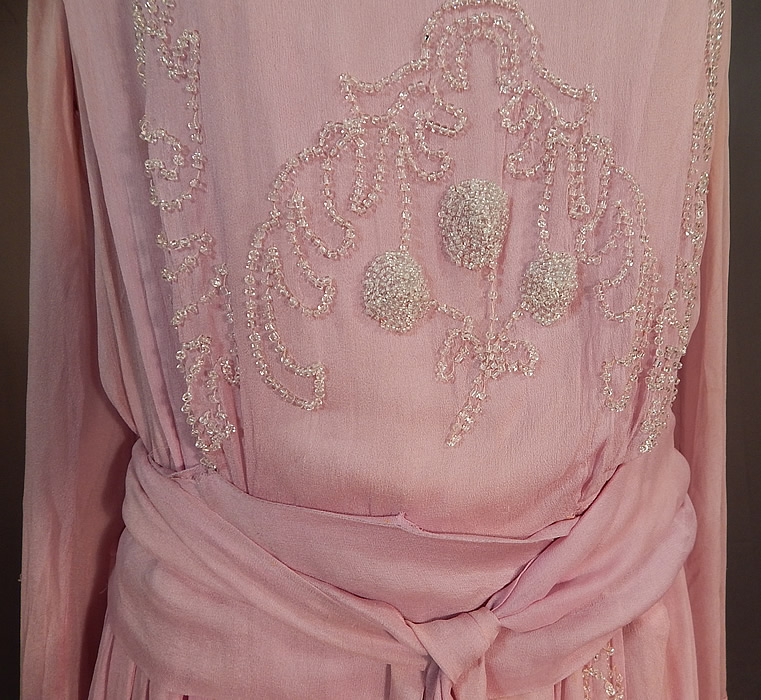 Edwardian Lilac Silk Chiffon Crystal Beaded Belted Evening Gown Dress
This lovely lilac evening gown dress is a long floor length with a fitted inside waistband, long full sleeves with wide cuffs, a layered tiered skirt with peplum draped sides, an attached belted tie sash with beaded tassel end, snap closures along the side top and is fully lined with a lilac silk short slip sewn inside.