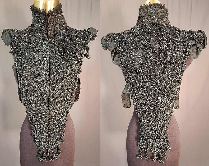 Victorian Black Jet Beaded Ball Fringe Mourning Mantle Cape Collar Pelerine
This antique Victorian era black jet beaded ball fringe mourning mantle cape collar pelerine dates from 1880. It is made of a black silk grosgrain ribbed textured fabric, completely covered with jet beading and beaded ball fringe trim along the shoulders and bottom ends. 