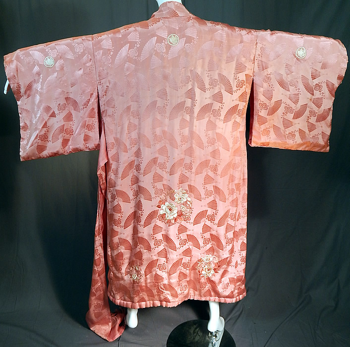 Vintage Japanese Pink Silk Damask Fan Floral Embroidered Mon Belted Kimono Robe
This pretty pink Japanese kimono robe has a white embroidered butterfly medallion mon emblem family crest on both the front and back top, is fully lined with inside pocket, full kimono sleeves, a rolled padded hem and matching fabric tie sash belt for closure. 