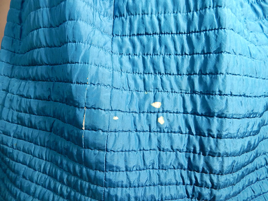 Victorian Bright Blue Silk Quilted Hand Stitched Winter Petticoat Hoop Skirt
The skirt measures 37 inches long, with a 26 inch waist and 100 inch circumference bottom. It is in good as-is condition, with only some small discoloration white bleach spots on the skirt and a small 1 inch split in the silk fabric near the bottom front (see close-ups). This is truly a rare blue color undergarment and wonderful piece of antique Victoriana wearable art!