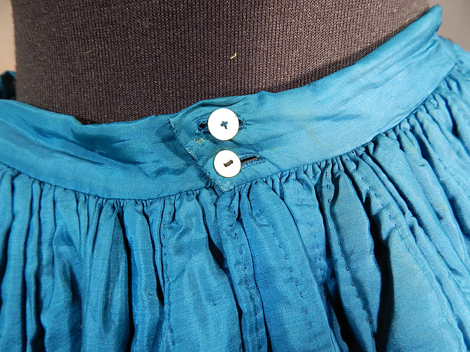 Victorian Bright Blue Silk Quilted Hand Stitched Winter Petticoat Hoop Skirt
The skirt measures 37 inches long, with a 26 inch waist and 100 inch circumference bottom. It is in good as-is condition, with only some small discoloration white bleach spots on the skirt and a small 1 inch split in the silk fabric near the bottom front (see close-ups). This is truly a rare blue color undergarment and wonderful piece of antique Victoriana wearable art!