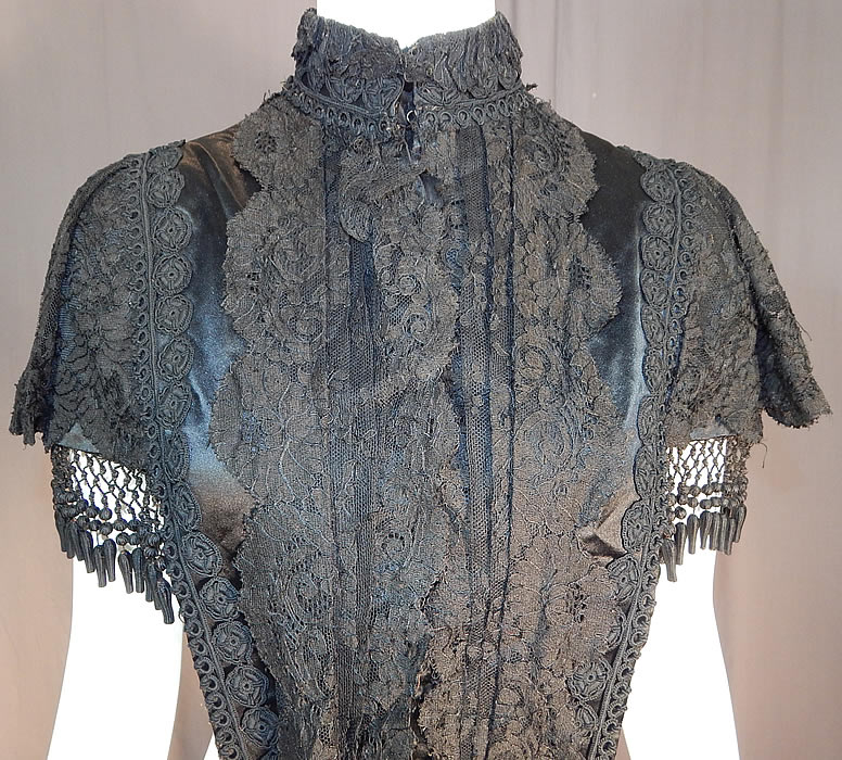 Victorian Black Silk Chantilly Lace Passementerie Mourning Mantle Pelerine Cape
This lovely lace cape mourning mantle has a short cropped style, with a high band collar, hook closures down the front, broad shoulders with silk ribbon bows on the back, ball fringe trim around the bottom, back top, a ribbon waistband strap underneath, long lappet ends on both the front and back and is fully lined inside. 