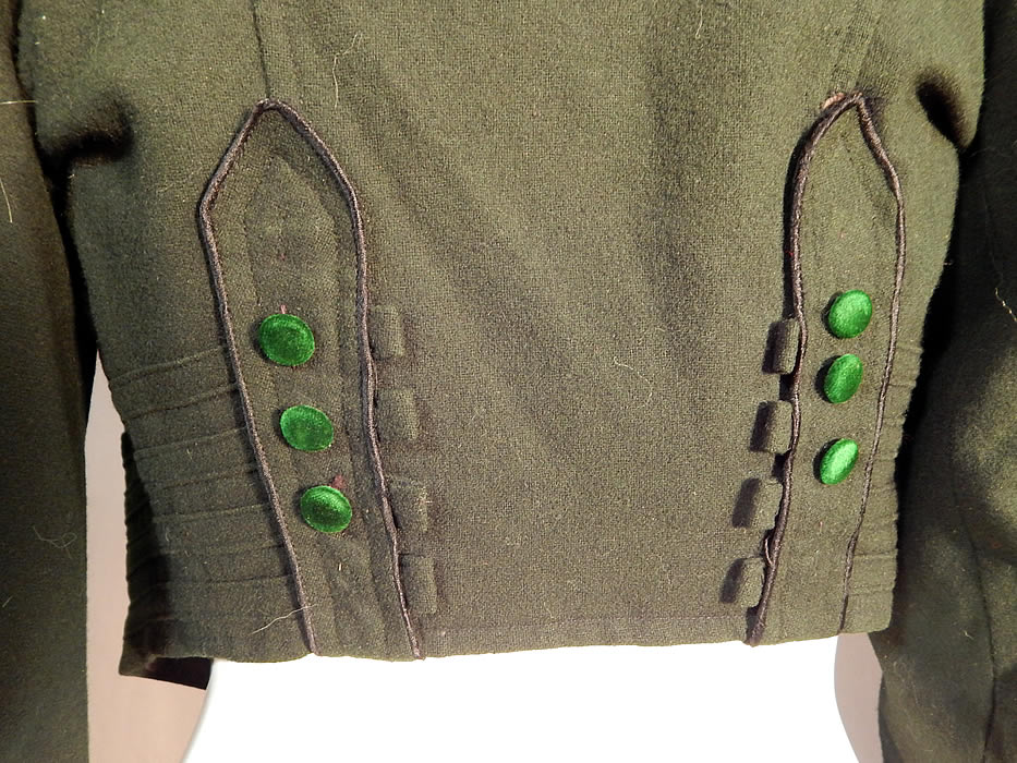 Victorian Dark Green Wool Velvet Trim Short Crop Coat Bolero Jacket
This glorious green short crop coat bolero walking suit spencer jacket bodice has a fitted tailored style, a fold over collar, gathered shoulders, long tapered sleeves with button trim cuffs, pleated details, front hook closures and is fully lined in a dark green silk fabric.