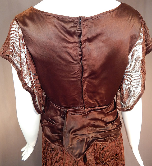 Vintage Brown Silk Lace Handkerchief Skirt Rosette Ribbon Trim Flapper Dress
This fabulous flapper dress has short kimono style cutaway sleeves, a black net inside camisole lining the top only, an attached belted sash wide waistband, layered lace over skirt with an asymmetrical uneven handkerchief hemline and snap closures on the back.