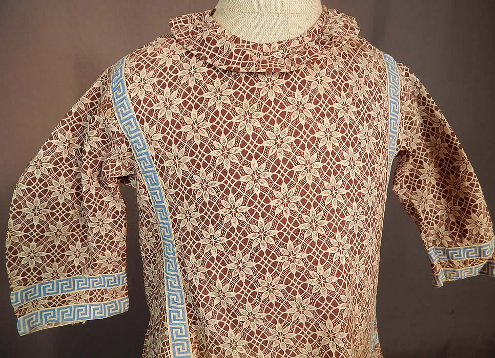 Victorian Childs Cotton Calico Brown Lace Pattern Print Greek Key Trim Dress
This charming child's dress has a loose fitting style, ruff collar, long sleeves, side skirt pocket, belted back, button back closures and is unlined.