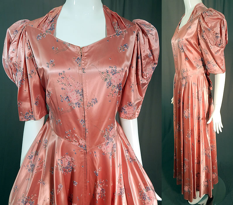 Vintage Pink Pastel Floral Rose Bouquet Print Satin Maxi Dress Gown
This pretty pink maxi dress floor length dressing gown has a long full skirt, with gathered shoulders, short puffy sleeves, a V front waist with belted back tie sash, front zipper closure and is unlined.