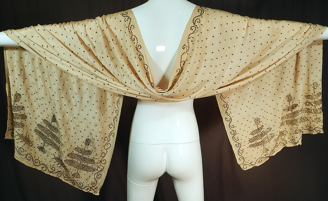 Vintage Art Deco Turkish Tel-Kirma Assuit Cream Silk Silver Stud Shawl Scarf
This amazing antique Art Deco Turkish tel-kirma assuit cream silk silver stud shawl scarf dates from the 1920s. It is made of an off white cream color silk fabric, covered with hand applied silver metal pieces done in a decorative Coptic designs along the ends, stars throughout and a scrolling spiral border edging.