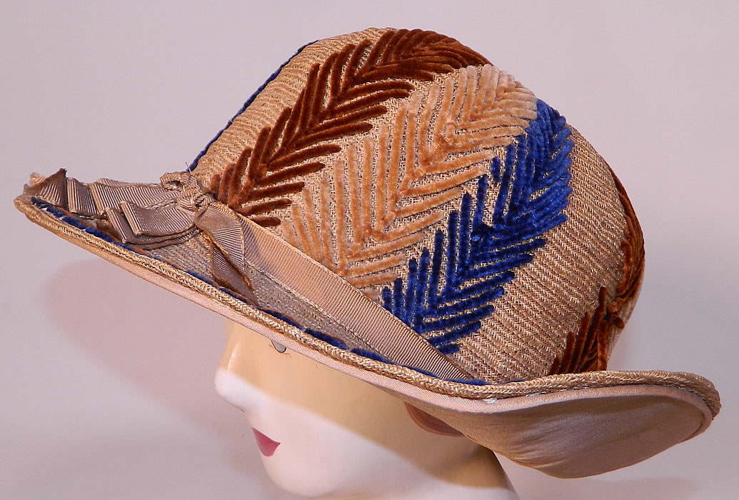 Vintage Natural Straw Wide Brim Chenille Embroidered Flapper Cloche Hat. It is made of a natural color tightly woven straw, with blue, brown and tan chenille decorative feather stitching embroidery work trim and a ecru silk grosgrain ribbon bow hatband trim.