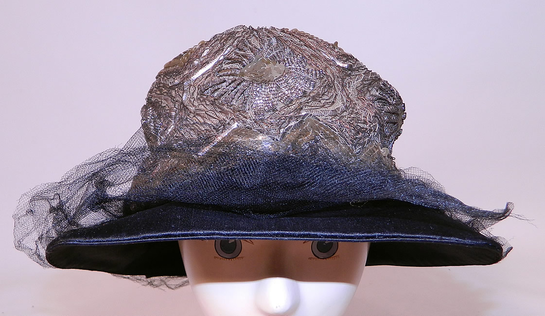 Vintage Emmaline Silver Lame Lam&eacute; Embroidered Sequin Trim Black Silk Wide Brim Cloche Hat. This vintage Emmaline silver lam&eacute; embroidered sequin trim black silk wide brim cloche hat dates from the 1920s.