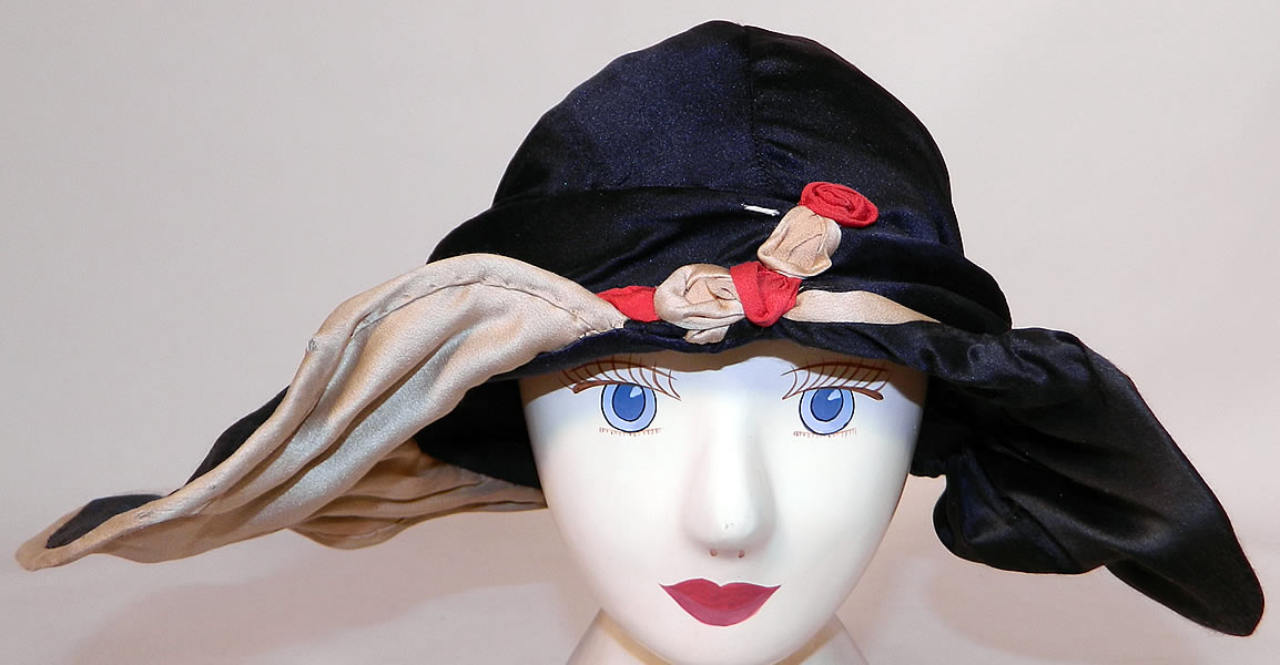 Vintage Art Deco Black & White Silk Red Rosette Wired Wing Brim Flapper Cloche Hat. This vintage Art Deco black and white silk red rosette wired wing brim flapper cloche hat dates from the 1920s.