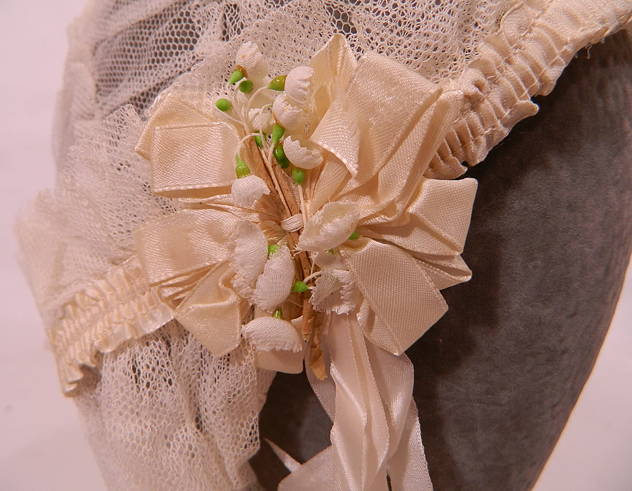 Vintage White Net Lace Silk Ribbon Bridal Bonnet Cap Headpiece Wedding Veil. It is made of a sheer white net fabric, with decorative white stitching along the bottom hem. 