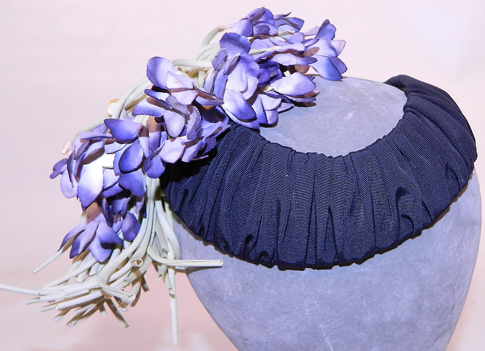 Vintage Black Silk Grosgrain Ribbon Purple Violet Flower Fascinator Hat.
This unique open crown fitted fascinator style cocktail hat sits atop the head and is lined in a gold metallic lam&eacute; fabric inside. 