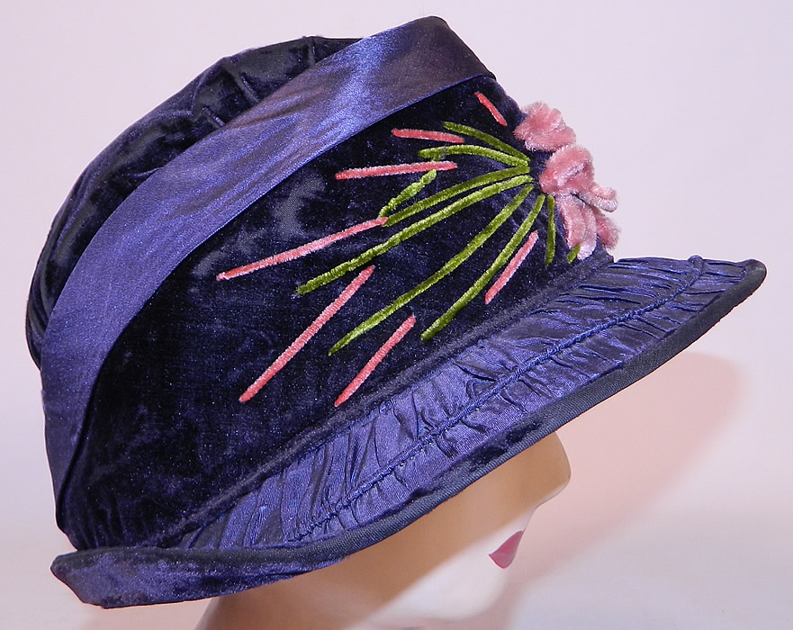 Vintage Periwinkle Silk Velvet Wide Brim Chenille Embroidered Flower Flapper Cloche Hat
This fabulous flapper cloche style hat has a form fitting style with an uneven asymmetrical oval shape brim which is wider on the sides and front, with ruched gathering tucks along the silk fabric brim and is fully lined inside the crown in pink silk. 