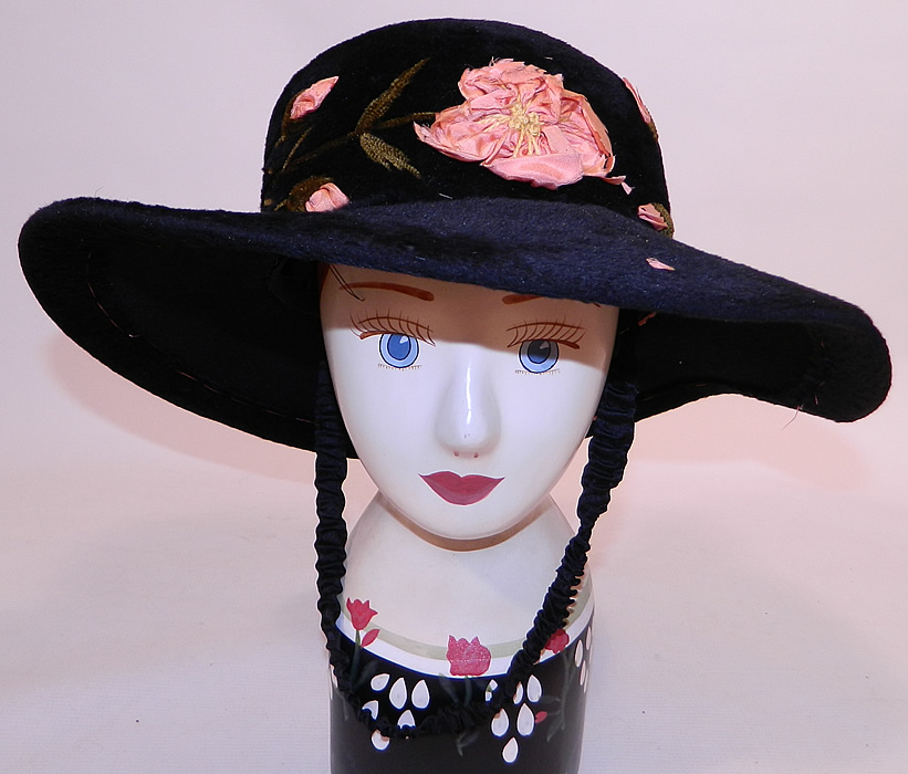 Edwardian Belle Epoque Black Plush Velvet Pink Silk Rosette Embroidered Wide Brim Hat
This Edwardian era Belle Epoque black plush velvet pink silk rosette embroidered wide brim hat dates from 1910.