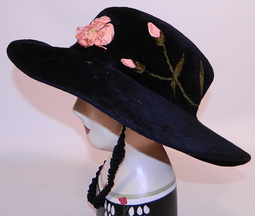 Edwardian Belle Epoque Black Plush Velvet Pink Silk Rosette Embroidered Wide Brim Hat
It is made of a black plush velvet felted fur nap, with pink silk ribbon work rosette flowers and green chenille embroidered leaf sprigs going around the crown.