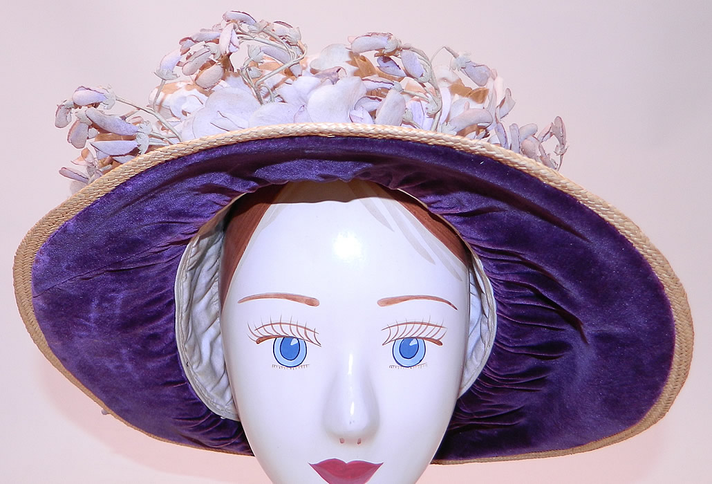 Edwardian Woven Natural Straw Purple Velvet Violet Flower Trim Wide Brim Hat
It is made of a tightly woven natural straw, with purple velvet fabric under the brim, around the brim and a garland wreath of faded purple violet flowers trim.