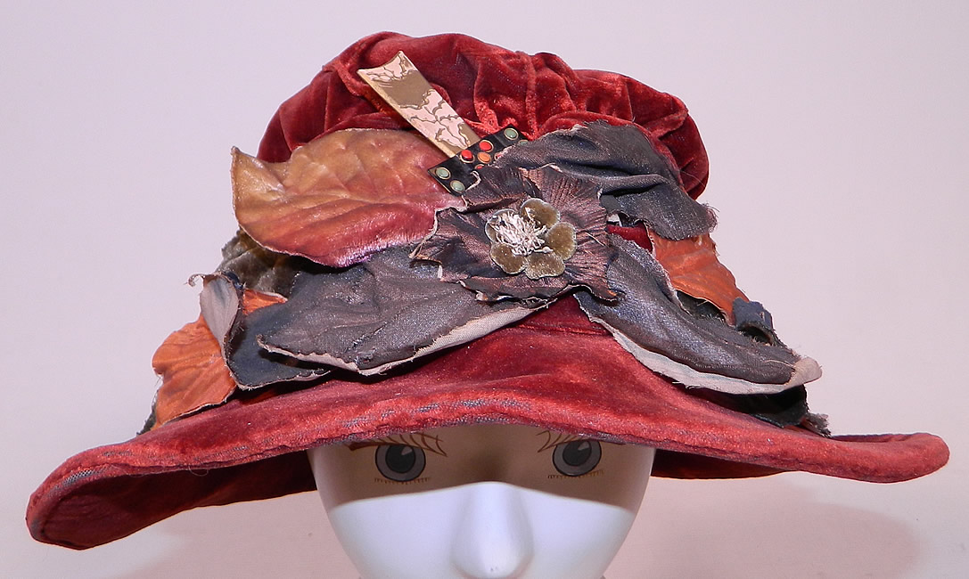 Vintage Autumn Burgundy Red Velvet Silver Lame Leaf Trim Wide Brim Cloche Hat Lamé
This vintage autumn burgundy red velvet silver lamé leaf trim wide brim cloche hat dates from the 1920s.