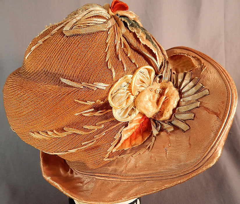 Vintage M. Lurie & Co Harvest Gold Woven Silk Ribbon Rosette Wide Brim Cloche Hat
This autumn fall color inspired hat has an uneven asymmetrical oval shaped brim, which is wider along the sides, front and has a slouched round crown. 