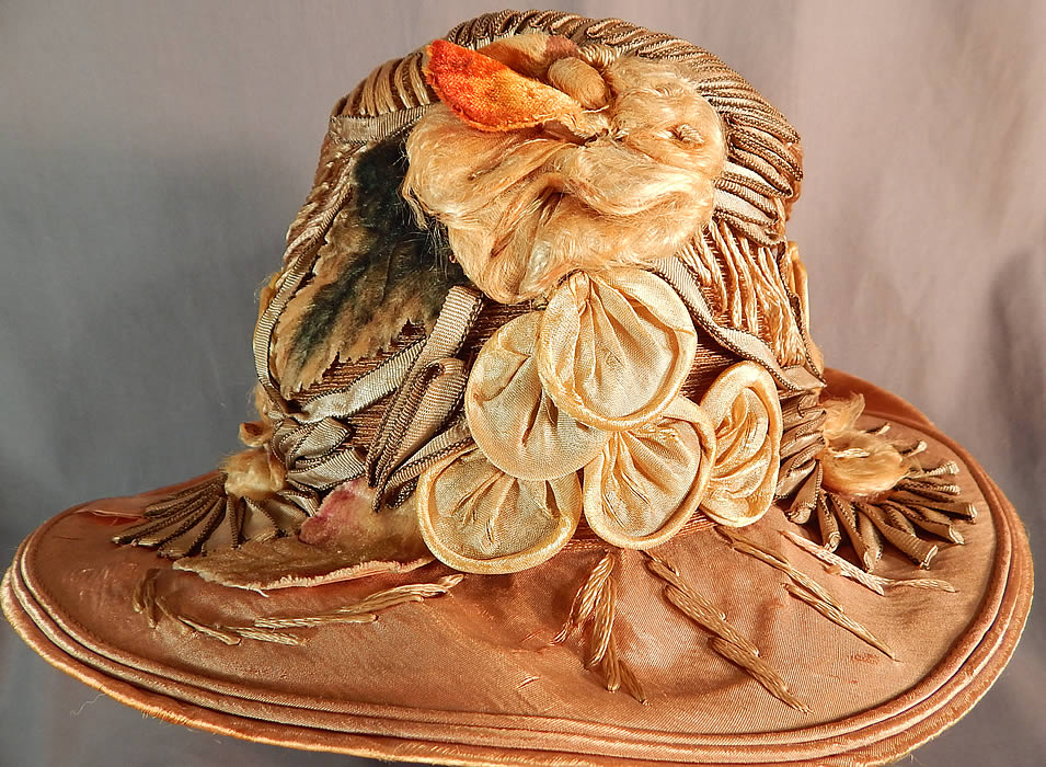 Vintage M. Lurie & Co Harvest Gold Woven Silk Ribbon Rosette Wide Brim Cloche Hat
It is in fair as-is condition, with some wear and frayed splits on the silk brim and inside lining. 