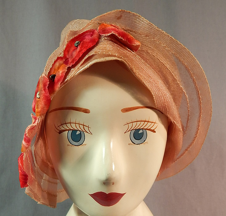 Vintage Art Deco Woven Pink Pastel Red Velvet Flower Flapper Cloche Hat
The hat is made of a sheer woven pale pink pastel horse hair net straw, with reddish orange ombre velvet flower applique trim on one side.