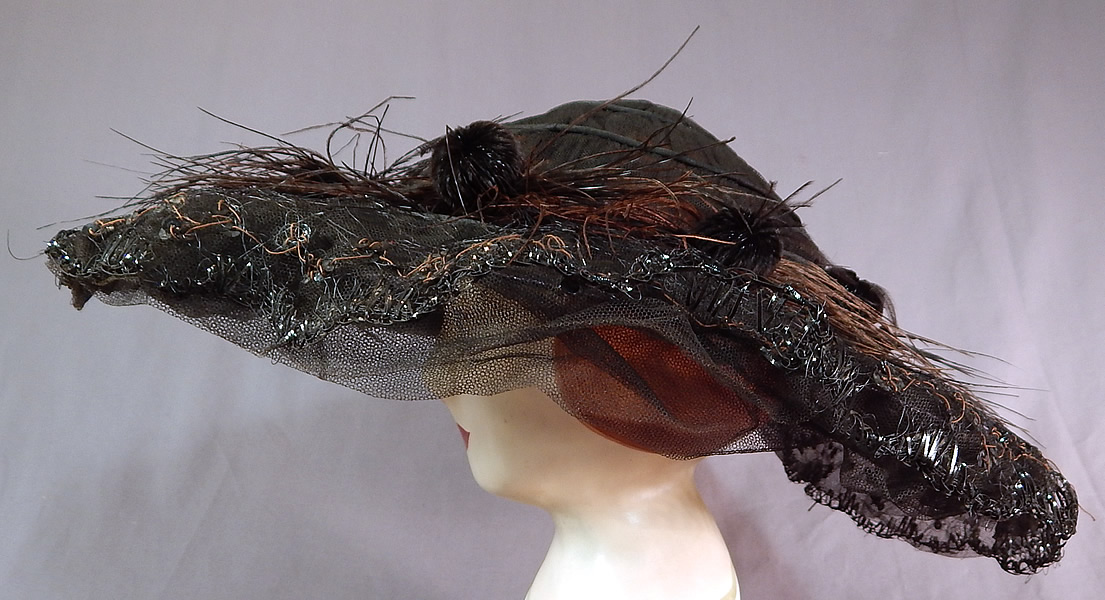 Edwardian Black Tulle Net Sequin Feather Trim Large Wired Wide Brim Hat
It is made of a black sheer tulle net fabric covering a wired brim with black straw stitching edging.