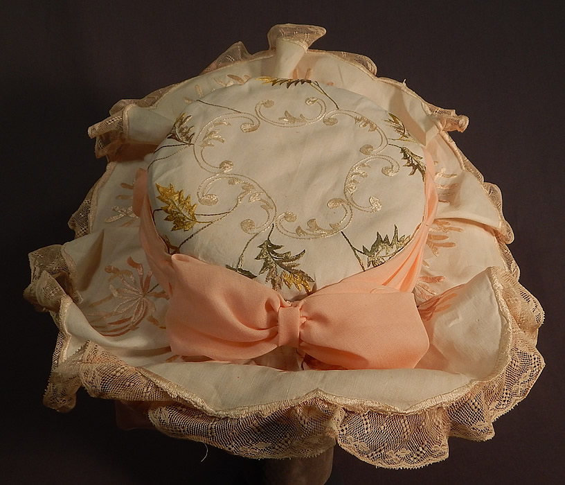 Victorian Style Ruth Stockley Society Silk Embroidery Floral Peach Bonnet Hat
There is cream lace trim ruffle edging the brim, a peach ribbon hatband bow and pastel silk flower, bow trim on the back. This beautiful belle epoque bonnet style hat has an upturned wide brim with ruched pleated gathered peach fabric underneath, a tall round crown which is fully lined and would have sat atop a large full Gibson Girl style updo hairdo secured with long hat pins. 