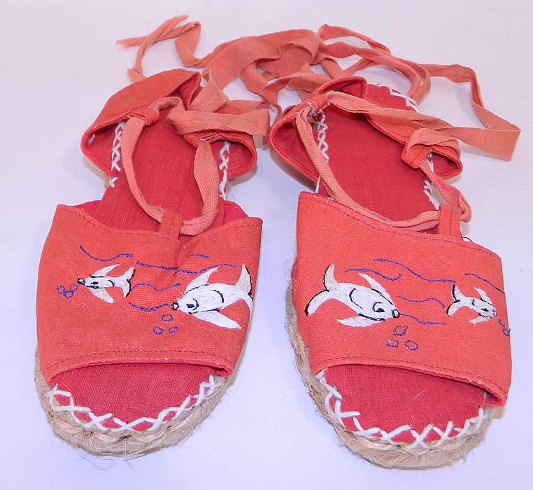 Vintage Red Linen Goldfish Ankle Tie Rope Sole Childrens Beach Sandal Shoes. These charming children's summertime beach sandal shoes have woven rope bottom soles, with heel caps, a red linen inside lining, white decorative cross stitching and red ribbon lacing ankle tie straps.