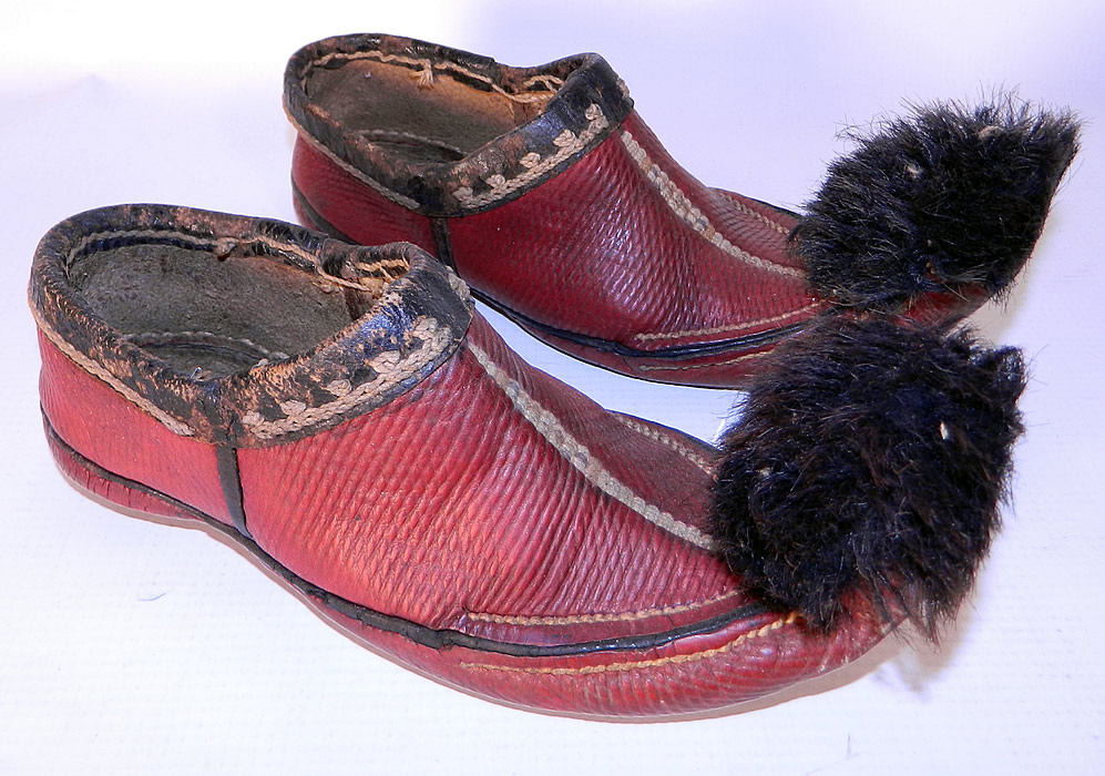 Vintage Greek Opanke Tsarouhi Childs Red Pompom Shoes & Folk Doll. The shoes are hand stitched, made of red leather, black leather trim, with white cord embroidery work and black fur pompoms on the front upturned curled toes.