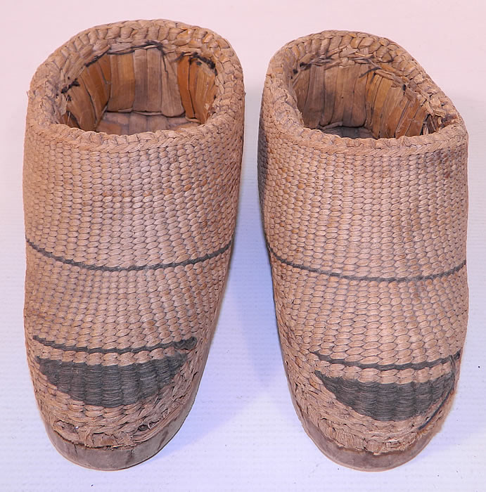 Antique Chinese Woven Braided Straw Hand Carved Wooden Farmers Shoes. This pair of antique Chinese woven braided straw hand carved wooden farmers shoes date from the late 19th century. They are made of a tightly woven braided straw with a dyed black decorative stripe design and hand carved wooden soles.