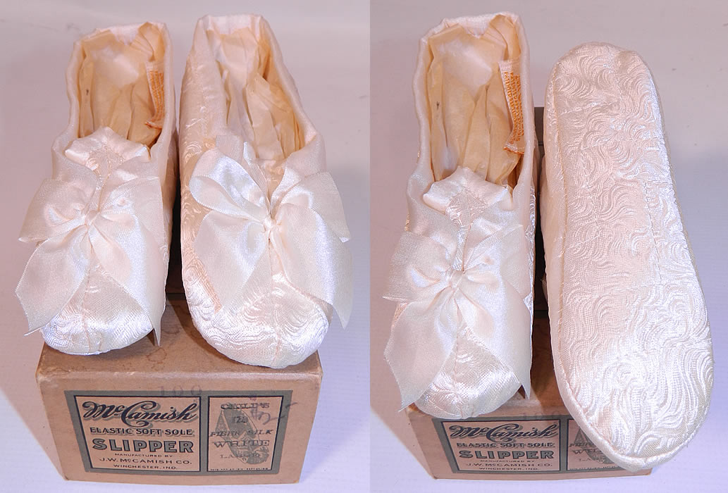 Vintage McCamish Funeral Burial Child's White Satin Slipper Shoes. They are made of a feather textured white silk satin brocade fabric with decorative white silk ribbon bow trim on the fronts. 