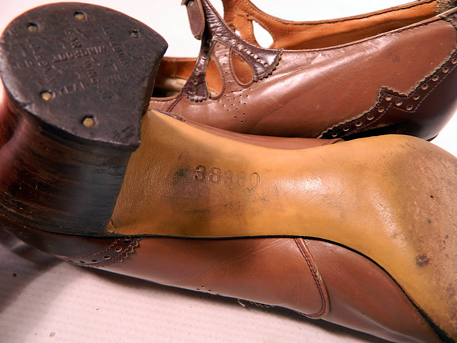 Vintage Two Tone Punchwork Brown Leather Buckle Strap Mary Jane Shoes. They are stamped on the bottom soles and insides with "38360". The shoes measure 10 1/2 inches long, 2 3/4 inches wide, with 2 1/2 inch high heels. 